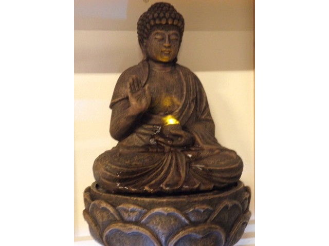 Budha med lys og rindende vand
